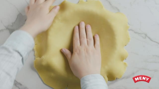Sikt mel og bakepulver, og bland inn i deigen. Ha deigen jevnt utover i en smurt terteform, eller paiform, på ca 22 cm i diameter.