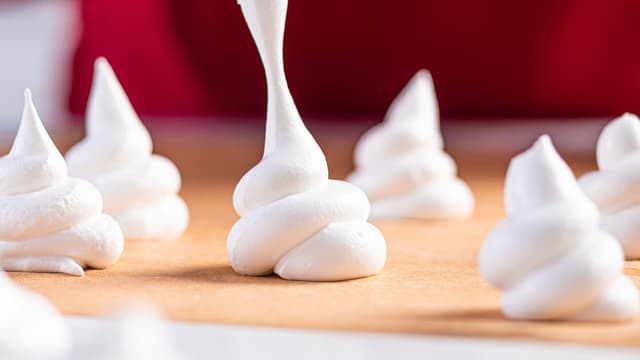 Hell deigen over i sprøyteposer, og sprøyt marengsen til den fasongen du ønsker på et bakepapir.