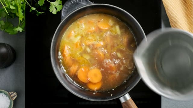 Tilsett buljong og appelsinjuice. Legg på lokk og la suppen småkoke i ca. 20 minutter.