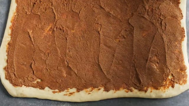 **Kanelboller:** Strø litt mel utover bakebordet og ta deigen ut av bakebollen. Kna den raskt med hendene. Kjevle så deigen til et rektangel, ca 30x50 cm. Smør fyllet utover hele flaten.