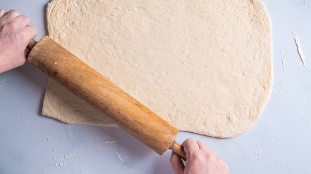 Del deigen i to, og legg den ene deigen tilbake på benken med mel og kjevle den ut til en rektangel som er ca 30x60 cm.