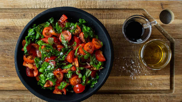 Bland tomatene sammen med grovhakket basilikum, litt olivenolje, noen dråper balsamicoeddik, en klype salt og kvernet pepper.