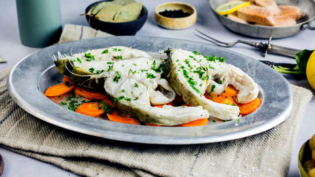 Server fisken med grønnsaker og saus.