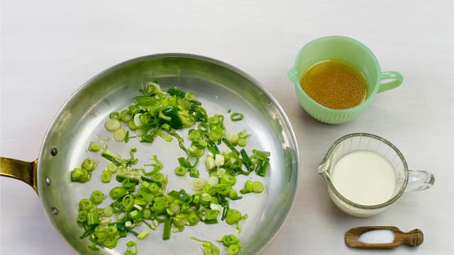 Hakk og fres hvitløk og vårløk i olje i en stekepanne. Ha i fløte og grønnsakskraft, smak til med salt og pepper og la koke i ca. 1 min.