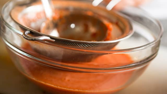 Gni suppen gjennom en sil. La tomatsuppen stå i kjøleskapet frem til servering.