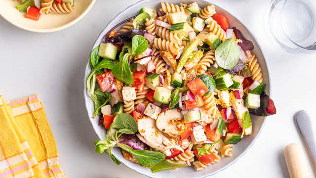 Kutt opp grønnsakene mens pastaen koker. Ha den ferdigkokte pastaen i en stor bolle sammen med ost, salat, tomat, agurk, rødløk og avokado. Hell over vinaigretten rett før servering og vend alt godt sammen.