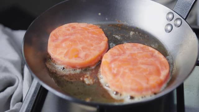 **Lakseburger:** Krydre lakseburgerne med salt og pepper. Stek dem i litt olje til de er gylne og så vidt gjennomstekt. Dette tar ca. 1 minutt på hver side.