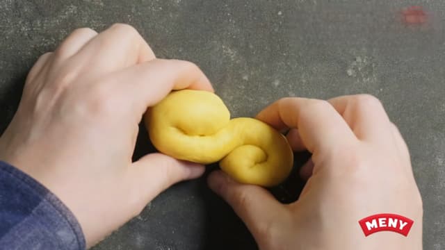 **Form lussekattene:** Når deigen er ferdighevet, deler du den i 15–20 emner. Trill hver del til en pølse og form en S. Bruk litt Jyttemel til utbaking.