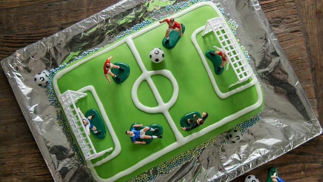 Pynt kaken med seigmenn med tannstikkere som spillere og til mål kan du bruke sjokoladepinner.