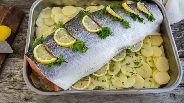 **Laks med sitronskiver:** Skjær 5-6 vertikale snitt i skinnet på begge sider av laksen, ca. 2 cm dype. Fyll lommene med finhakkede urter og sitronskiver. Strø også salt og pepper i hver lomme.