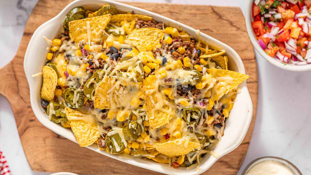 Gratiner nachochipsen midt i ovnen ved **200 grader i ca. 5-10 minutter**, til osten er smeltet og gyllen.