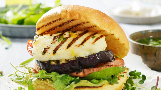 Smør majones på bunnen, legg lagvis salat, grillede grønnsaker, søtpotet, tomat og halloumi. Avslutt med pesto og toppen av burgerbrødet.