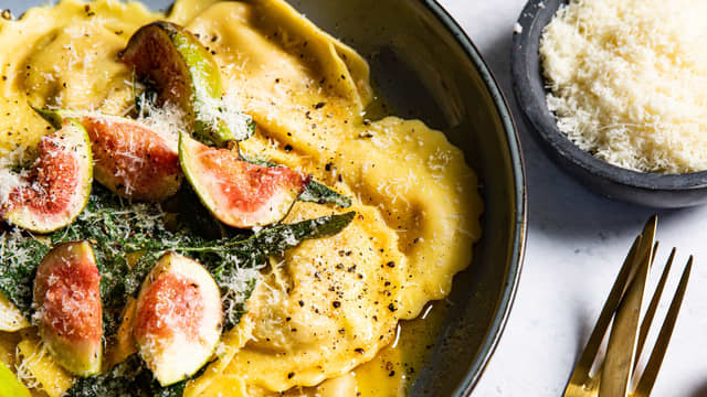 Anrett ravioli på to tallerkener og topp med salviesmør og fiken.