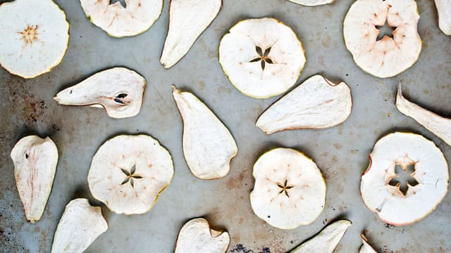 Skjær epler og pærer i tynne skiver, 1–2 mm. Legg skivene utover stekebrett dekket med bakeduk eller silikonmatte (bakepapir har lett for å krølle seg).