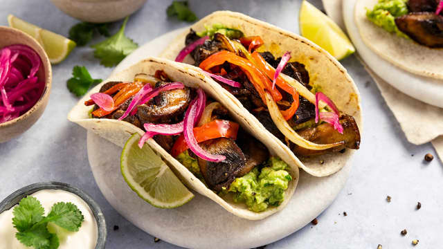 Anrett tortillalefsene med guacamole, stekt sopp, paprika og løk, og topp med rømme, tacosalsa, koriander og syltet rødløk.