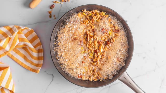 Ta stekepanna av varmen og ha i honningen. Vend nøttene inn i honningen. Avkjøl blandingen.