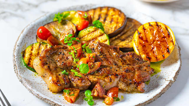 Anrett de grillede nakkekotelettene sammen med grillede grønnsaker, tomater og urteolje. Server den grillede sitronen ved siden av, slik at du kan presse over sitronsaft før retten nytes.