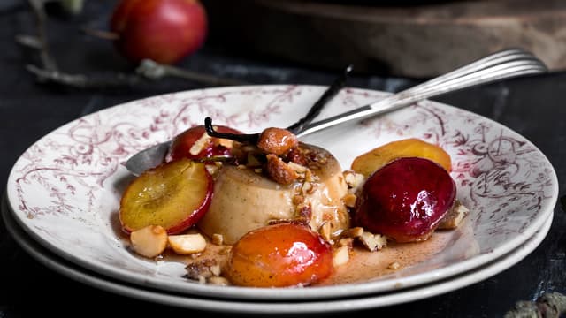 Server kaffe-panna cotta med stekte plommer, sausen fra pannen og hakket Honey Roasted nøttemix.