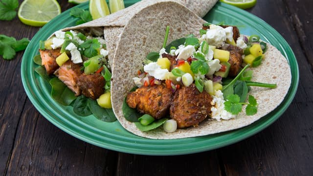 Fyll tortillaene med babyspinat, stekt laks, salsa og fetaost. Topp det hele med et dryss vårløk og frisk koriander. Nå har du en litt sunnere, men like smakfull taco!