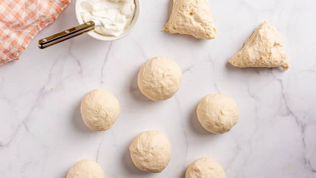 Del deigen i 8 like emner og form hvert emne til en liten bolle. Legg bollene på et brett. Dekk dem til og la etterheve i ca. 20 minutter.