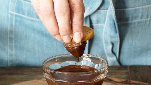 Dypp de frosne kakene raskt i den smeltede sjokoladen slik at det legger seg et fint lag utenpå sjokoladekremen.