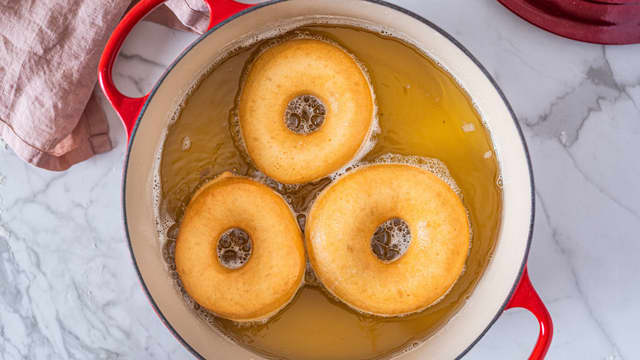 Slipp donutsene forsiktig ned i oljen. Pass på så du ikke dypper fingrene ned i oljen, eller at det spruter olje, det er veldig varmt. Snu donutsene noen ganger underveis i friteringen.