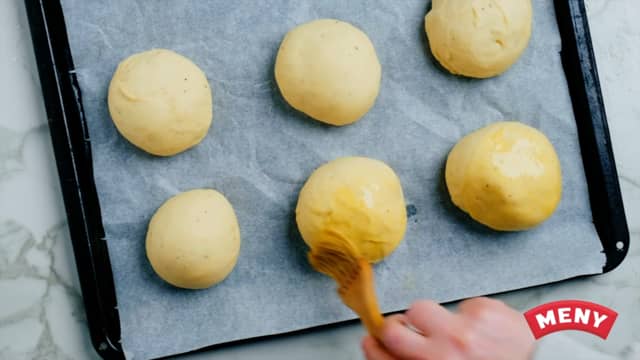 **Stek bollene:** Pensle bollene med egg, og stek dem midt i ovnen ved 220 grader i 10–12 minutter. Avkjøl bollene på rist.