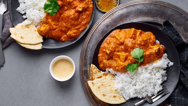 Anrett tikka masala, brød, raita og salat på tallerkener. Server.