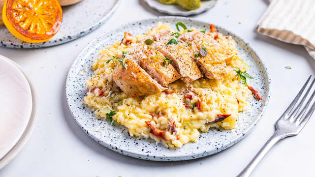 Tilsett smør, revet parmesan og soltørket tomat. Rør godt, og la risottoen hvile under lokk i 2-3 minutter før servering. Topp med parmesan og friske urter.