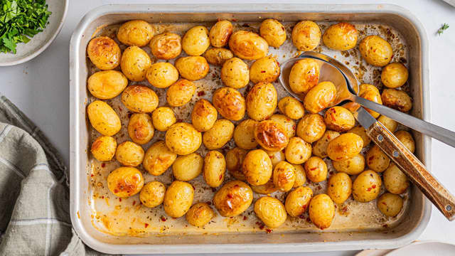 Bland sammen hvitløk, sitronzest- og saft, krydder, kyllingkraft og olivenolje. Legg perlepotetene i en ildfast form og hell over blandingen.