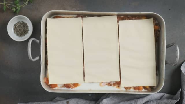 Legg tomatsaus, lasagneplater og revet ost lagvis i en ildfast form, i den rekkefølgen.