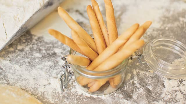 Forvarm ovnen til 175 grader og kle to bakeplater
med bakepapir.
Del deigen i 24 like biter.
Rull hver bit til en lang pinne som er ca like lang som
bredden på bakeplaten. Strø over revet parmesanost,
nykvernet pepper og noen få klyper havsalt.