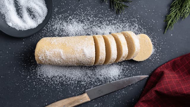 Ta pølsa ut av plasten og rull den i sukker. Skjær deigpølsa i 12 skiver.