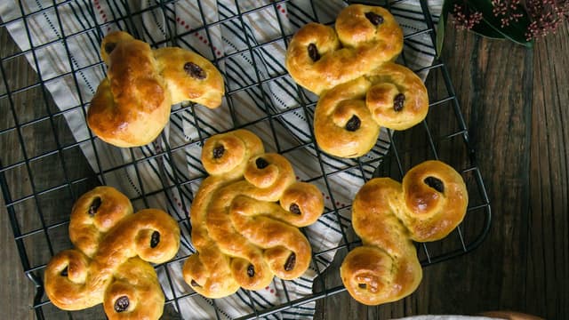 Pensle med sammenvispet egg og pynt med rosiner. **Stek lussekattene på 255 grader i 10-12 minutter**. Avkjøl litt på rist, de smaker best litt lunkne.