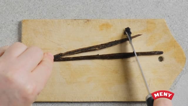 Del vaniljestangen i to og skrap ut vaniljefrøene med en kniv. Bland vaniljefrøene med sukkeret.