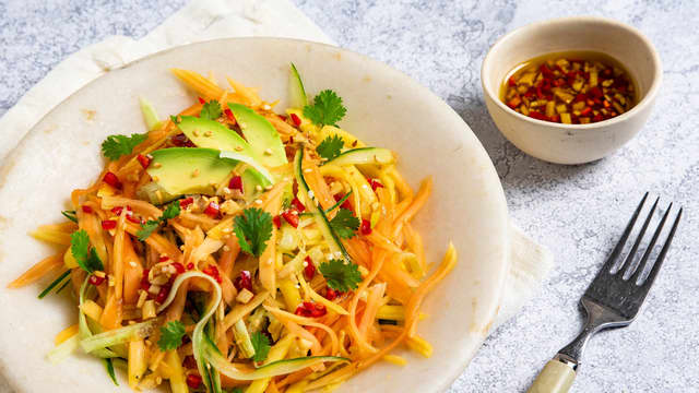 Bland frukten og grønnsakene i en salatbolle og ringle over dressing. Topp gjerne med litt hakkede peanøtter.
