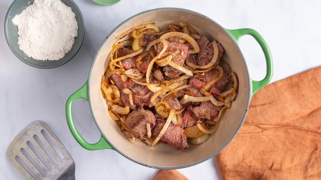 Ha kjøttet tilbake i kjelen og tilsett hvetemelet. Stek videre under omrøring i ca. 1 minutt.