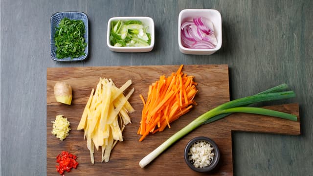 Skjær grønnsakene i strimler, finhakk chili, hvitløk, ingefær og persille.