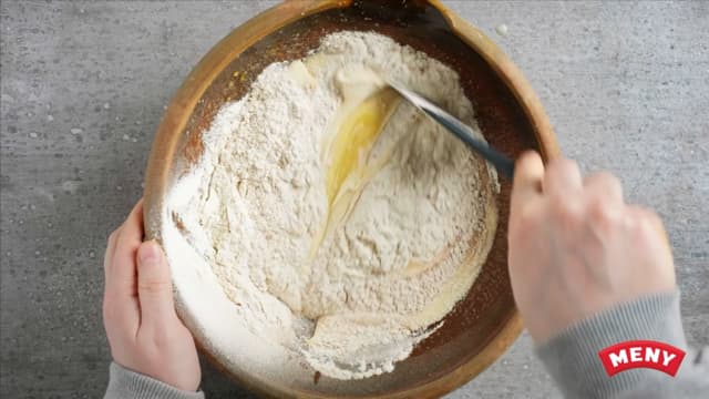 Ha mel og bakepulver over i en sil og sikt det over i bollen. Vend inn i kakerøren med en slikkepott.