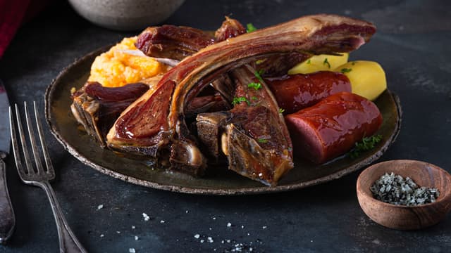 Server med klassisk tilbehør som vossakorv, rotmos, kokte poteter og en god saus.