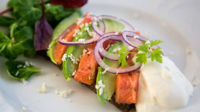 Legg rakfisk og avokado side om side på rugbrødskivene, og fordel pepperrotkremen på hvert smørbrød. Pynt slutt med rødløksringer og et ekstra dryss revet pepperrot.