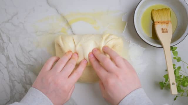 **Forheving:** Legg deigen på benken og fold kantene inn mot midten. Snu deigballen så foldene du lagde kommer ned mot benken, og dra deigen mot deg 2-3 ganger for å stramme opp deigen.