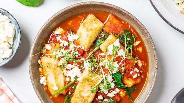 Varm tomatsausen i en kjele til kokepunktet, tilsett spinat og rør til den faller sammen. Tilsett gnocchiene og topp med smuldret fetaost og karse.