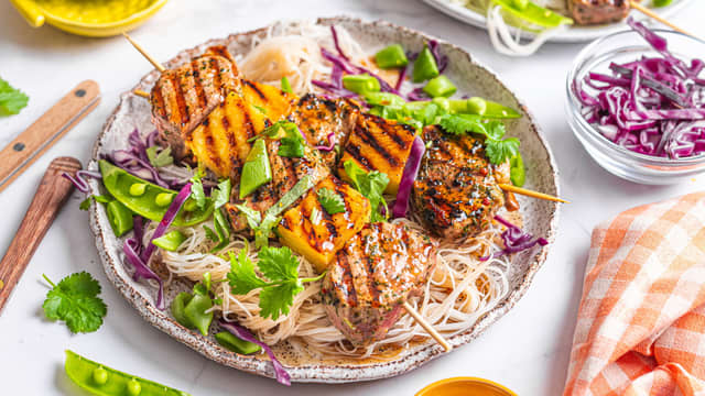 Bland sammen grønnsaker, nudler, koriander og soyaglaze. Anrett salaten og grillspydene på tallerkener, og topp gjerne med litt ekstra frisk koriander.