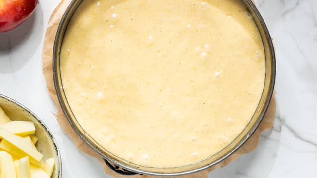 Kle den runde kakeformen med bakepapir og smør formen med formfett eller smør. Hell kakerøren over i formen.