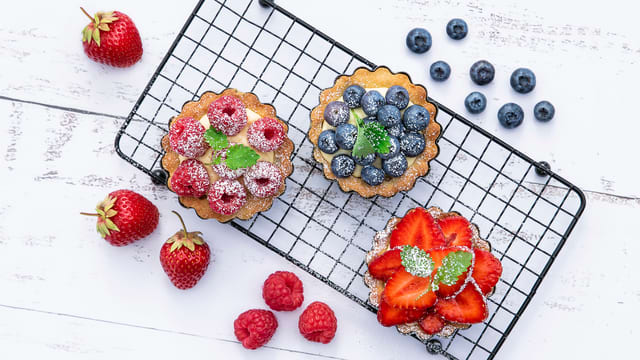 Søte terter med vaniljekrem og friske bær