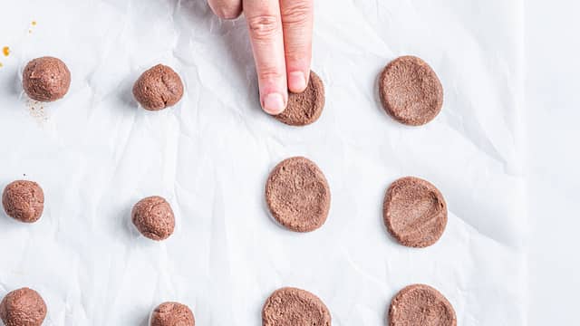 Klem kulene flate med fingertuppene eller bunnen av et glass. Legg kulene med god avstand, slik at de ikke flyter inn i hverandre når de steker.