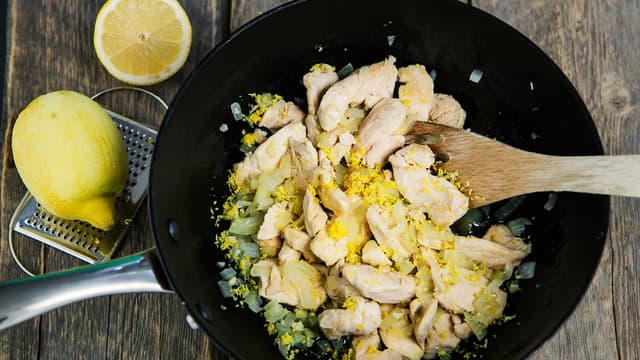 Stek kyllingstrimler, finhakket løk og finrevet sitronskall i olivenolje til kyllingen er godt brunet på alle sider.