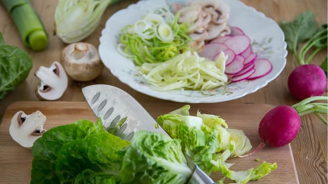 Skjær grønnsakene i tynne skiver eller strimler. Det er viktig at de ikke er for tykke, da blir de ikke ferdigstekte og møre sammen med laksen.