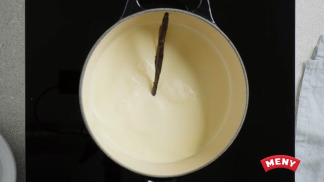 Del vaniljestengene i to og skrap ut frøene. Ha både frø og stenger sammen med melk og fløte i en kjele og kok opp.